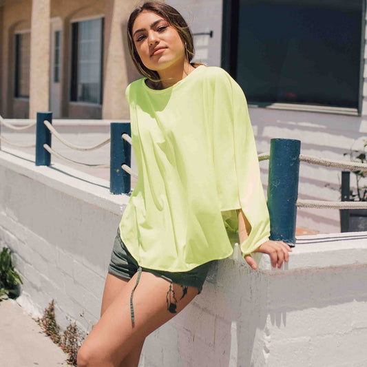 woman wearing eclipse Aurora cover-up shawl at beach.
