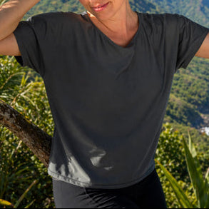 Woman standing under a tree with a scenic background of mountains and ocean in eclipse boatneck.