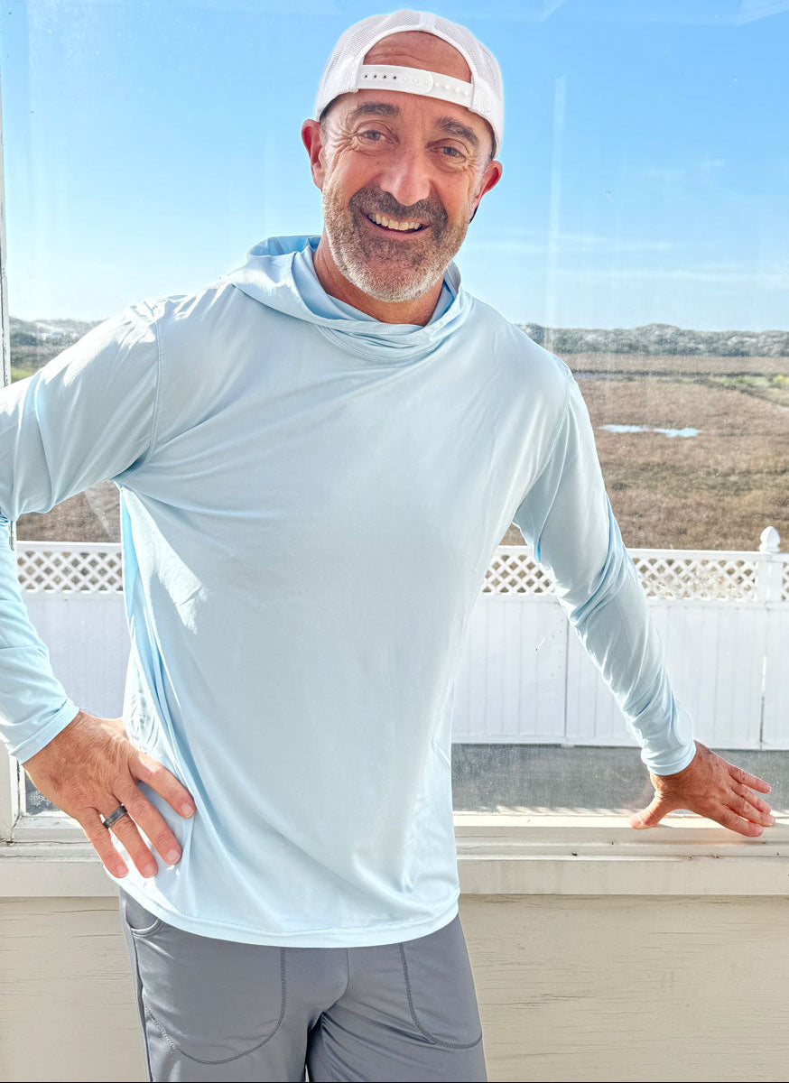Man wearing eclipse Hoodie long-sleeve shirt and the eclipse Jogger on a balcony with a scenic view.