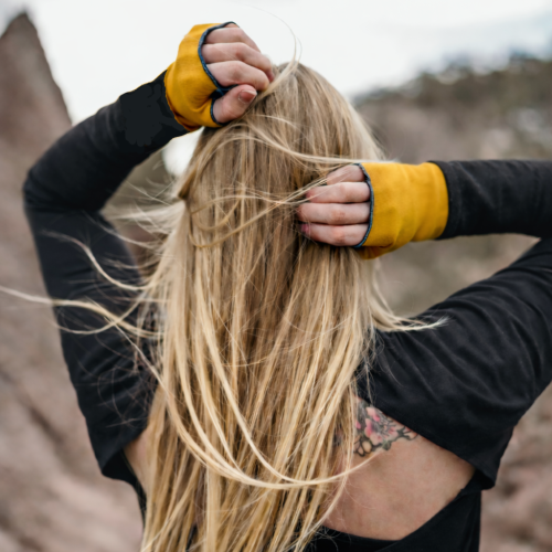 woman wearing eclipse gloves in the mountains
