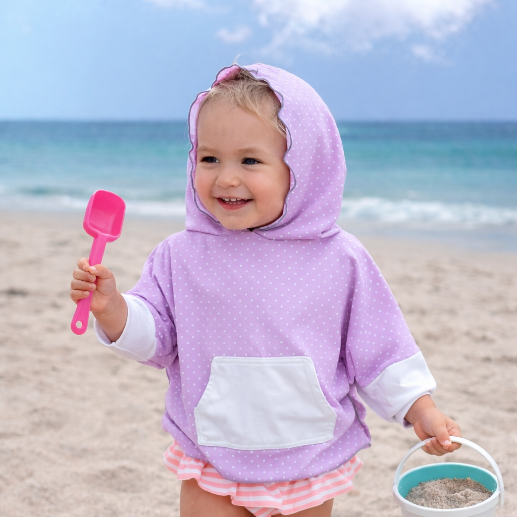 infant girl on beach wearing eclipse poncho in pink polka